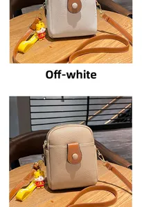 Detail of lychee pattern faux leather mobile phone bag with cute tiger charm accessory