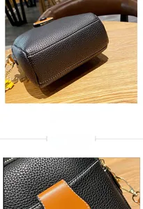 Detail of pebbled black faux leather phone bag with brown strap and contrast white stitching