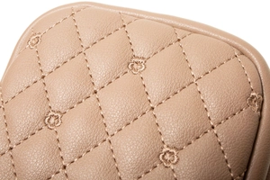 Macro detail of beige quilted PU leather with fine floral embroidery and diamond stitching