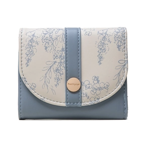 Detail of floral pattern on bi-color faux leather wallet with gold magnetic snap closure