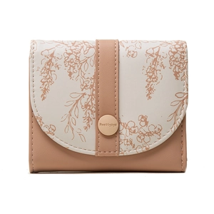 Detailed close-up of metallic snap closure with engraved logo on floral trifold wallet