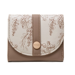 Close-up of floral print leather wallet featuring a branded metal snap closure detail