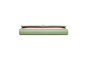 Detail of green and beige bi-color envelope wallet with fine stitching and leather texture