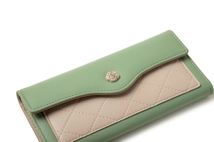 Detail of green and beige long wallet with rose ornament and quilted pattern