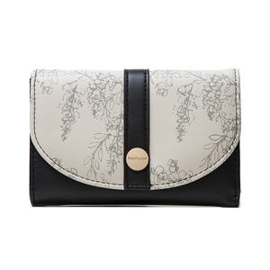 Detail of floral print flap and gold metal clasp on a bicolor leather wallet