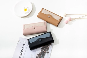 Detail of color-block PU leather long wallets featuring quilted texture and rose metal clasps
