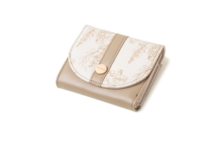 Detailed side view of a beige trifold wallet featuring floral print and gold metal clasp