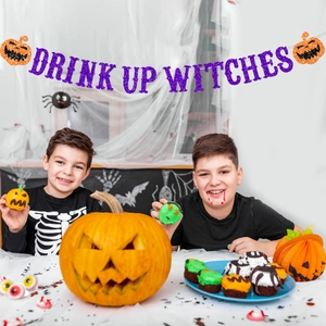 Halloween glitter banner Drink Up Witches with orange pumpkin decorations for party setup