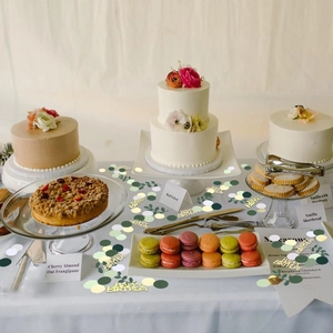 Detail of Happy Birthday gold confetti and green leaf sequins scattered on dessert table