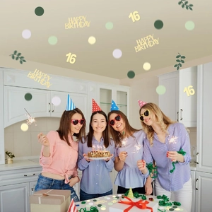 Close-up of 16th birthday confetti with golden letters and green leaves for party tables