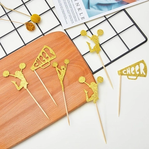 Detailed close-up of golden glitter cheerleading cake toppers with CHEER megaphones