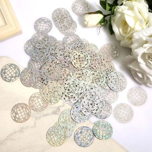 Macro shot of silver disco ball sequins on marble surface with white rose decoration
