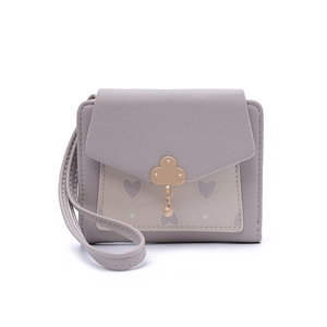 Detail of lavender short wallet featuring lychee texture and clover metal clasp
