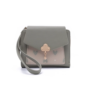 Detail of short leather wallet with heart pattern and gold floral metal clasp closure