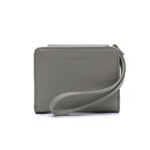 Close-up of gray pebble leather wallet featuring Prettyzys logo and gold zipper detail