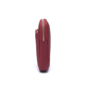 Macro view of textured burgundy leather wallet with durable metal zipper closure