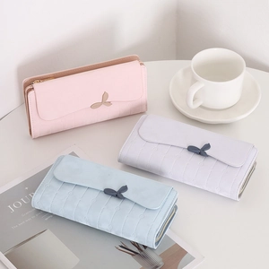 Detailed view of long wallets in pink, purple, and blue with metal leaf buckles