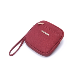 Detail of burgundy zip coin purse with fine faux leather texture and gold logo