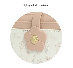 Detailed close-up of pink PU leather purse featuring floral patterns and gold metal buckle