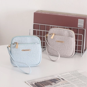 Close-up of minimalist short wallets in blue and grey with zippers and wrist straps