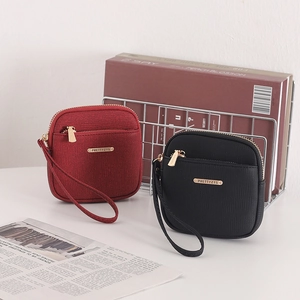Detail view of small square wallets in red and black with stylish gold metal plates