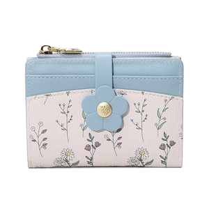 Detail of light blue floral wallet featuring a leather flower clasp and gold metal hardware