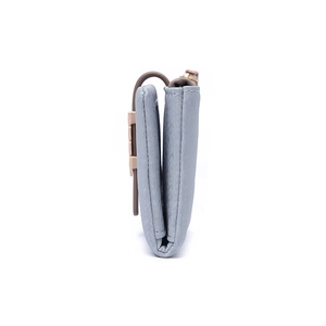 Detailed side profile of a grey-blue bi-fold wallet featuring pebble leather and a gold clasp