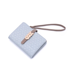 Close-up of light blue floral wallet featuring a gold leaf buckle and brown wrist strap