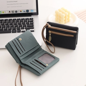 Litchi pattern leather wallet detail with card slots and leaf metal charm pendant
