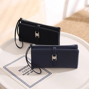Detail of long PU leather wallets in black and blue with heart buckle and wrist strap