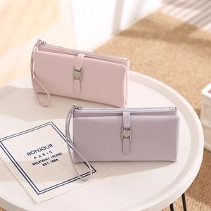 Detail of pink and purple long PU leather wallets featuring heart buckles and wristlets