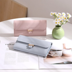 Detail of long PU leather wallets with gold leaf buckles in pink and light blue shades