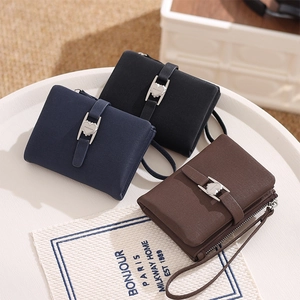 Detailed shot of three compact PU leather wallets with heart buckles and wrist straps