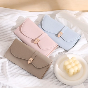 Detail of three PU leather trifold wallets with flower metal buckle on textured fabric