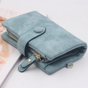 Detailed close-up of matte blue leather wallet featuring fine stitching and a gold D-ring
