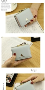 Detail of light blue tri-fold wallet with golden heart kiss lock and cute chick emblem