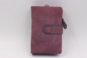 Close-up of matte purple vintage trifold wallet with gold metal D-ring and snap closure