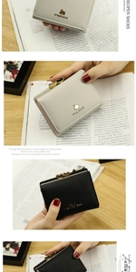 Detail of short leather wallets with heart-shaped metal clasps and animal patterns