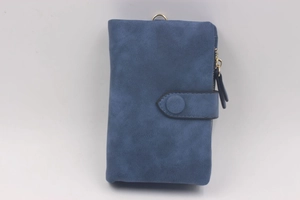 Close-up of blue matte wallet featuring snap closure and gold metal zipper detail