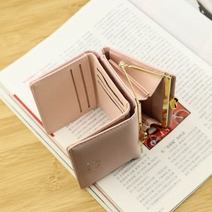 Interior detail of pink trifold wallet showing card slots and golden clasp coin pocket
