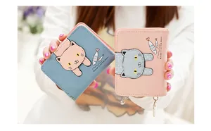 Close-up of cute cartoon cat wallets in blue and pink PU leather with zip and charms