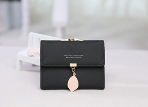 Detail of black tri-fold PU leather wallet with pink leaf pendant and gold hardware