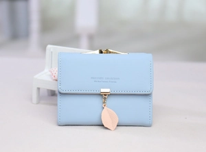 Light blue short tri-fold wallet for women with golden metal clasp and leaf pendant