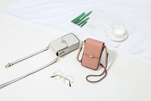 Dettaglio di mini borse a tracolla per cellulare in rosa e grigio con stampe floreali