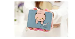 Close-up of blue cat wallet with cute fish print and delicate metal bow charm