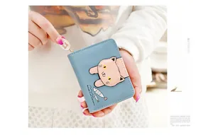 Detail of blue compact zip wallet with cute cartoon cat patch and gold bow charm