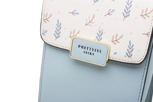 Détail du cuir bleu clair à texture litchi et du rabat floral avec une boucle en métal doré