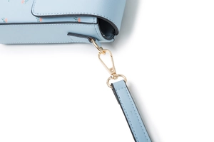 Dettaglio della borsa in ecopelle celeste con stampa floreale e chiusura dorata