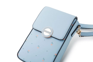 Dettaglio della borsa a tracolla floreale azzurra con chiusura dorata e trama fine