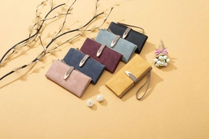 Flat lay of multiple long matte leather wallets in various colors with elegant V-metal clasp